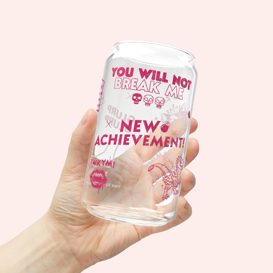 Clear glass tumbler with pink text and designs inspired by Dungeon Crawler Carl with quotes and imagery, held in a hand against a light pink background