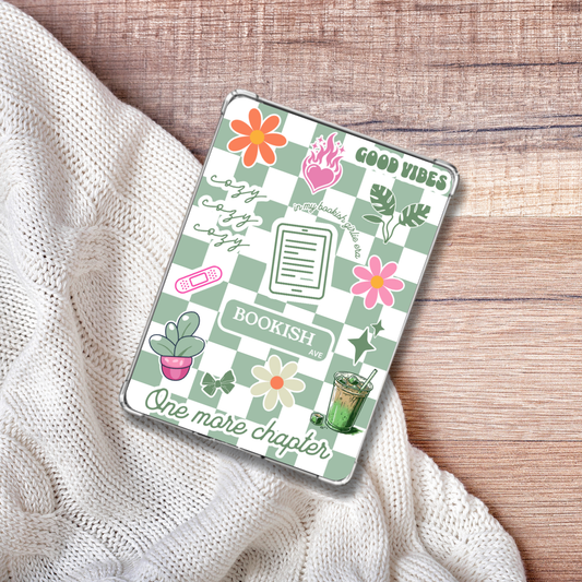 Cozy Matcha Green checkered Kindle Insert for Clear Case on a white blanket and wooden background