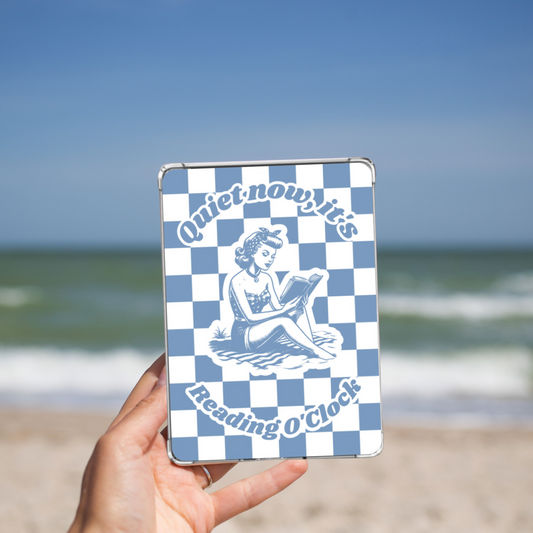 Woman holding the blue Retro Summer Beach reading Kindle insert while on a beach.