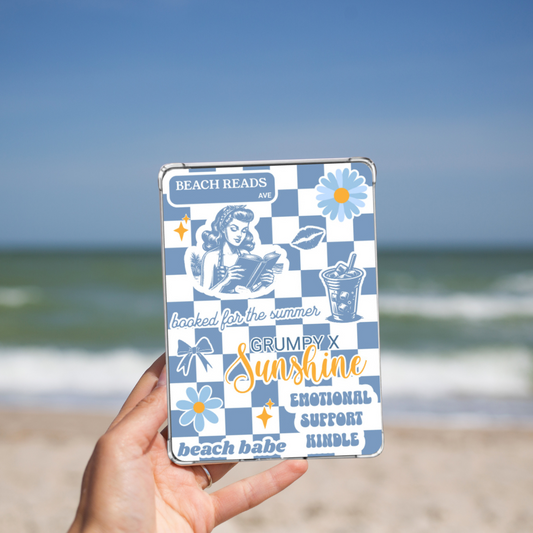 Woman holding the Grumpy x Sunshine Summer Kindle Insert for Clear Case while on a beach