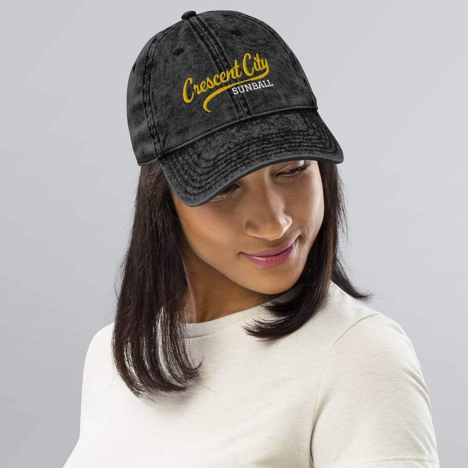 A woman wearing a hat that says Crescent city Starball, it's from the Crescent City book series by Sarah J Maas.