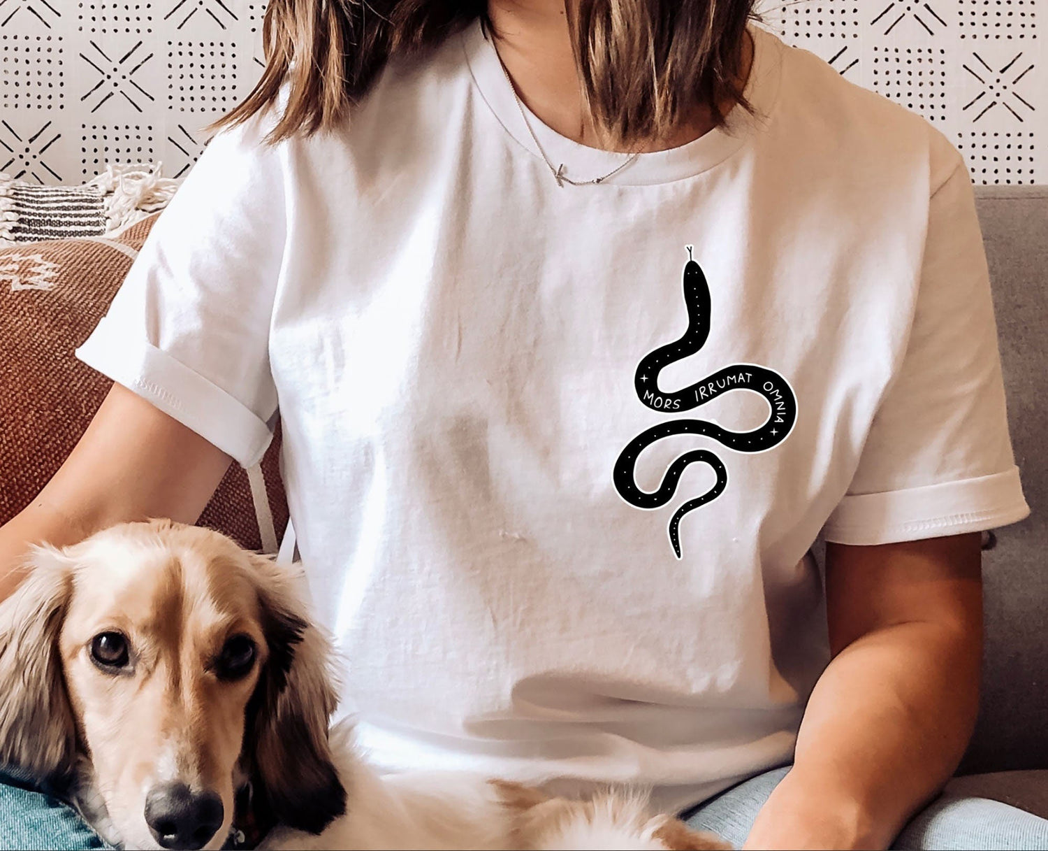 A model wearing a white shirt that has a snake on it, with a quote from Ninth House