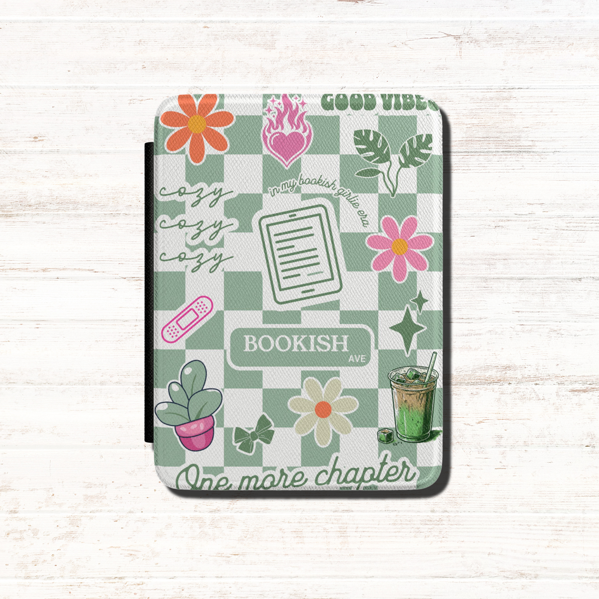  The case has a Matcha green and white checkerboard pattern with floral illustrations, the words 'BOOKISH AVE' and 'GOOD VIBES', One more Chapter, cozy cozy cozy and includes small decorative illustrations like matcha iced latte, coquette bows and a kindle. Designed by Starlit Prose Bookish Merch Australia.