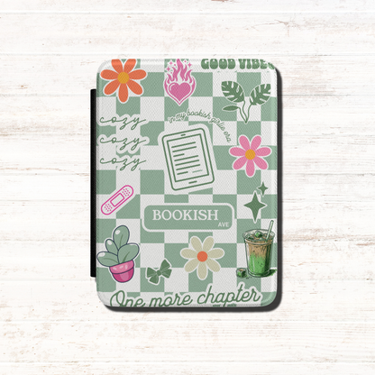  The case has a Matcha green and white checkerboard pattern with floral illustrations, the words 'BOOKISH AVE' and 'GOOD VIBES', One more Chapter, cozy cozy cozy and includes small decorative illustrations like matcha iced latte, coquette bows and a kindle. Designed by Starlit Prose Bookish Merch Australia.