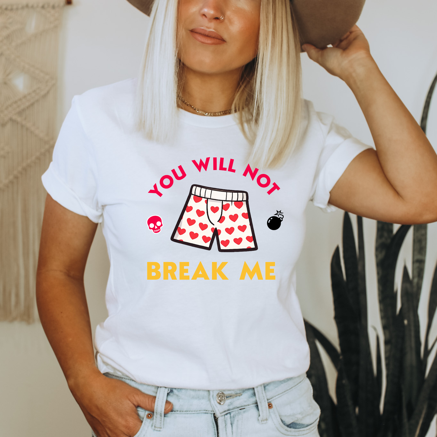 Person wearing a white tshirt that says "You will not break me" quote from Dungeon Crawler Carl book series. Includes graphics of Carl's heart boxer shorts | Starlit Prose Bookish Merch Australia