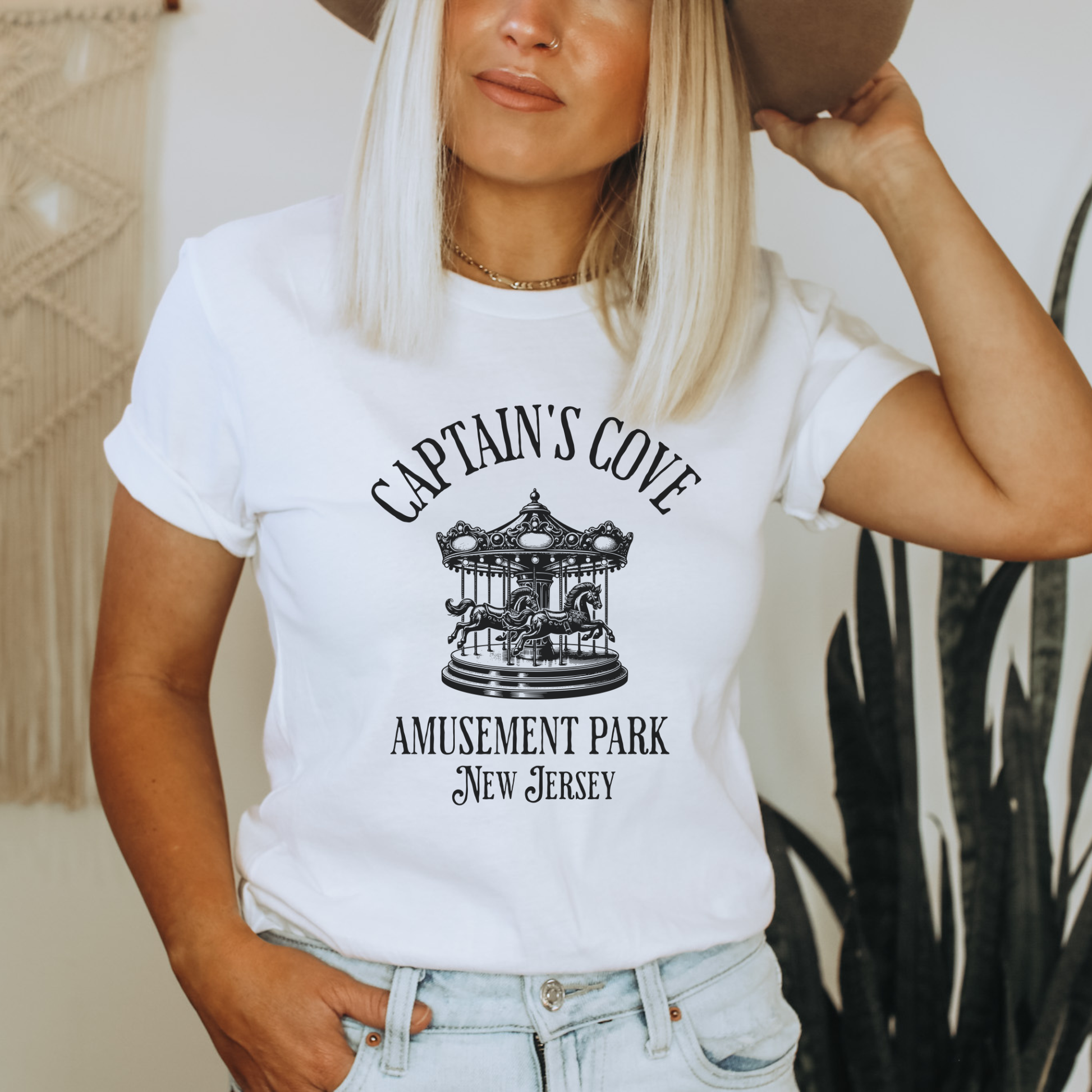 Person wearing a white t-shirt with 'Captain's Cove Amusement Park New Jersey' design.