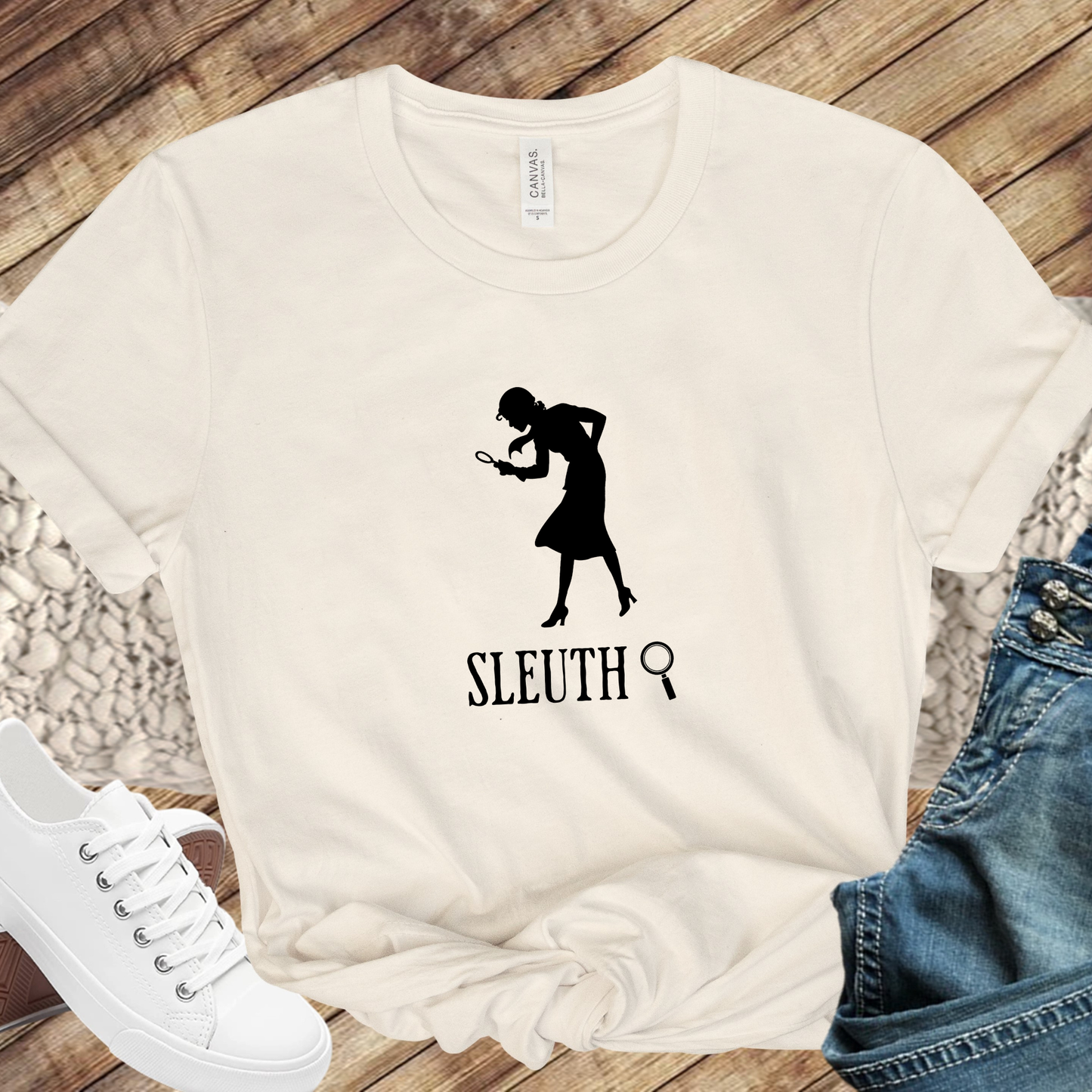 beige shirt with a silhouette of nancy Drew that says "Sleuth"