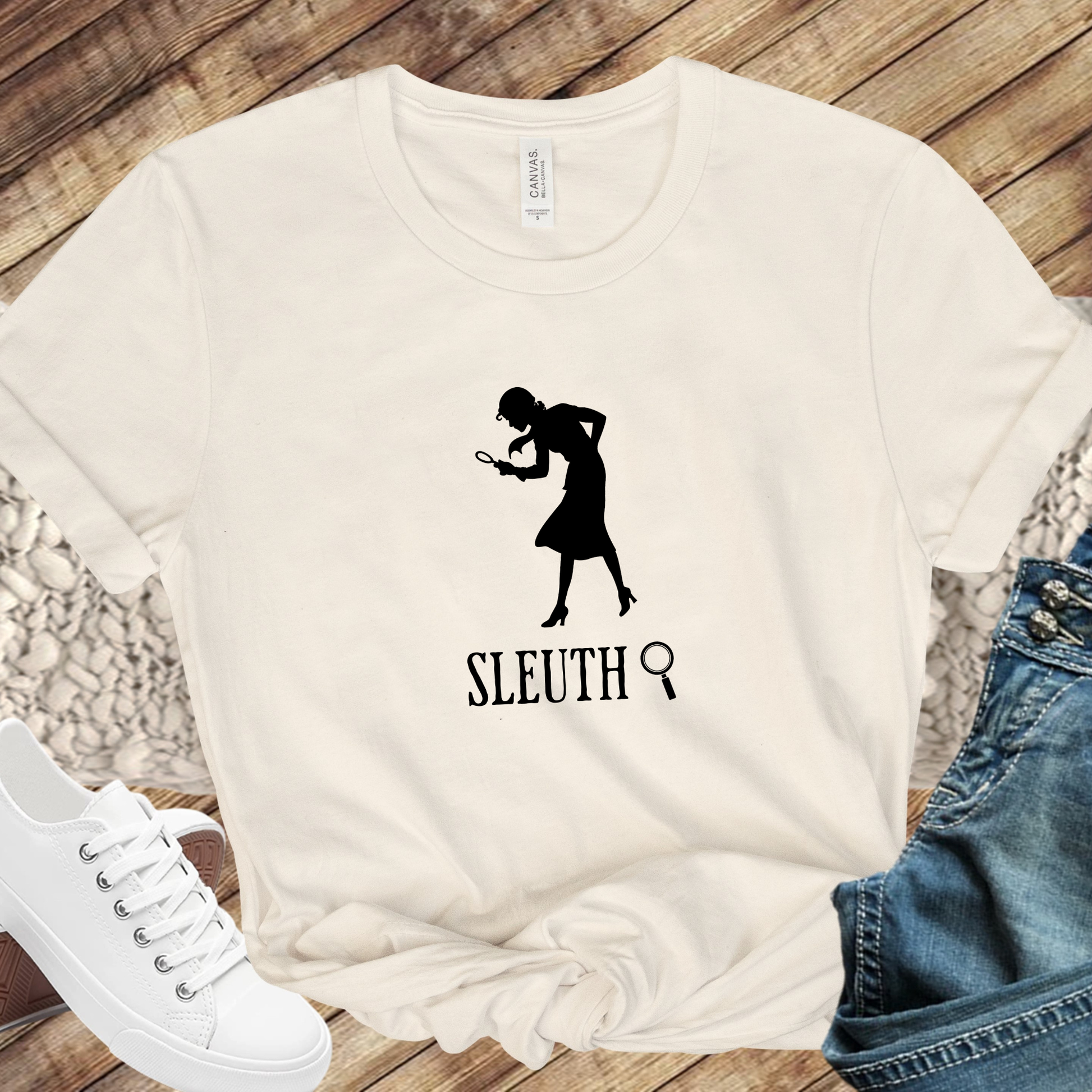beige shirt with a silhouette of nancy Drew that says "Sleuth"
