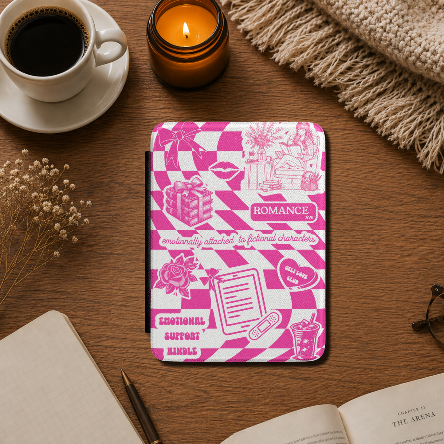 This playful pink Kindle case features a pink and white checkerboard background covered with cute illustrated details — from roses, books and iced lattes to a coquette bow, lips and a tiny bandaged Kindle. The design includes text that says "Romance Ave," "Emotionally Attached to Fictional Characters," "Emotional Support Kindle" and "Self Love Club" for a case that perfectly captures the experience of being a romance reader. Designed by Starlit Prose bookish merch australia.