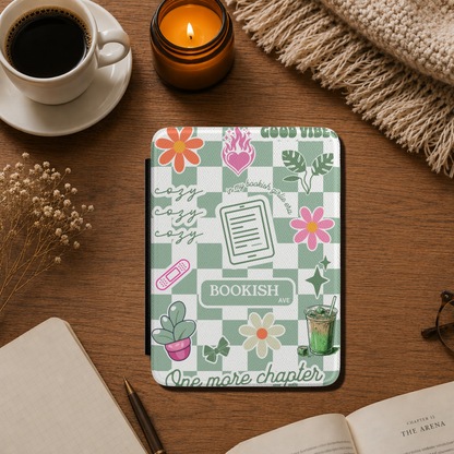 The case has a Matcha green and white checkerboard pattern with floral illustrations, the words 'BOOKISH AVE' and 'GOOD VIBES', One more Chapter, cozy cozy cozy and includes small decorative illustrations like matcha iced latte, coquette bows and a kindle. Designed by Starlit Prose Bookish Merch Australia.