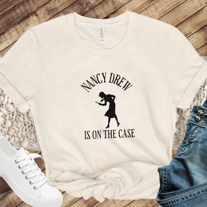 beige Shirt that says "Nancy Drew is on the Case" with a sihouette of Nancy Drew