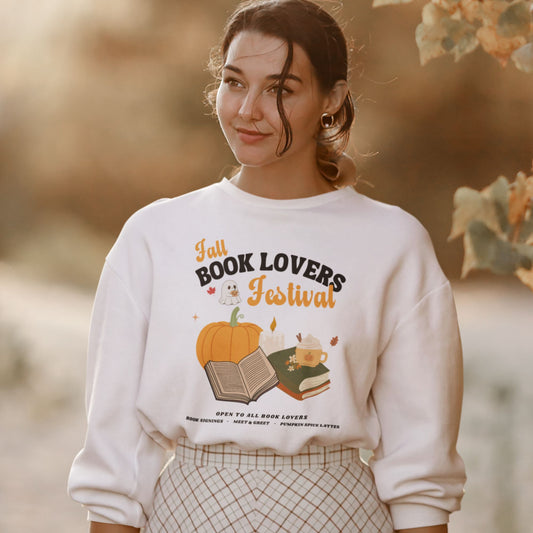 Woman wearing a white sweatshirt with 'Fall Book Lovers Festival' design featuring a pumpkin, books, and a ghost for a fictional Book Lovers Festival. Starlit Prose Bookish Merch Australia