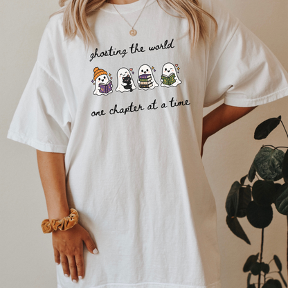 A woman wearing an oversized White Comfort Colors T-shirt with four cartoon ghosts reading books and the text 'ghosting the world one chapter at a time". Designed by Starlit Prose Bookish Merch Australia