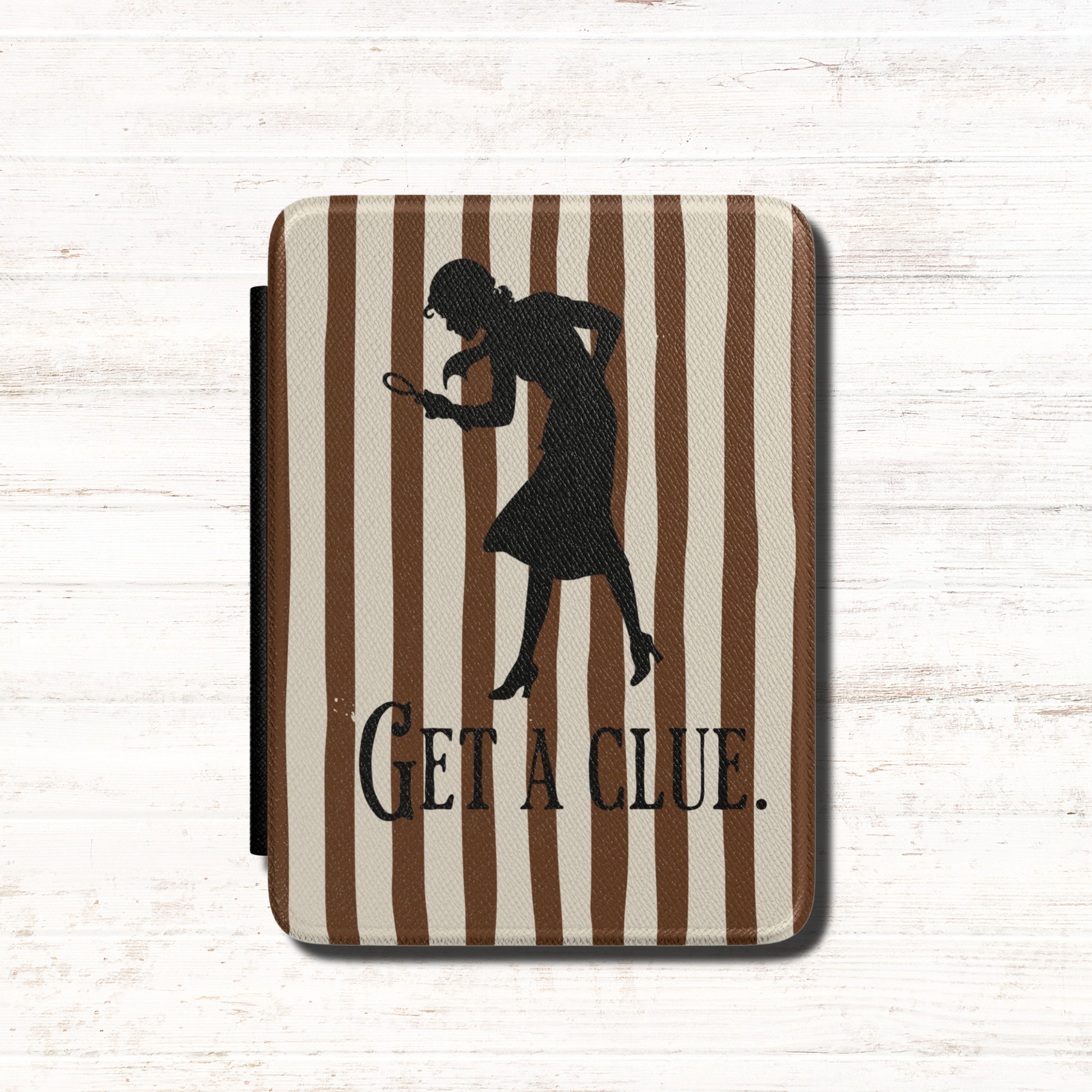 A kindle case featuring a vintage-style  Nancy Drew design with vertical brown stripes, a black silhouette of a Nancy Drew holding a magnifying glass, and the text 'GET A CLUE.' Designed by Starlit Prose Bookish Merch Australia.