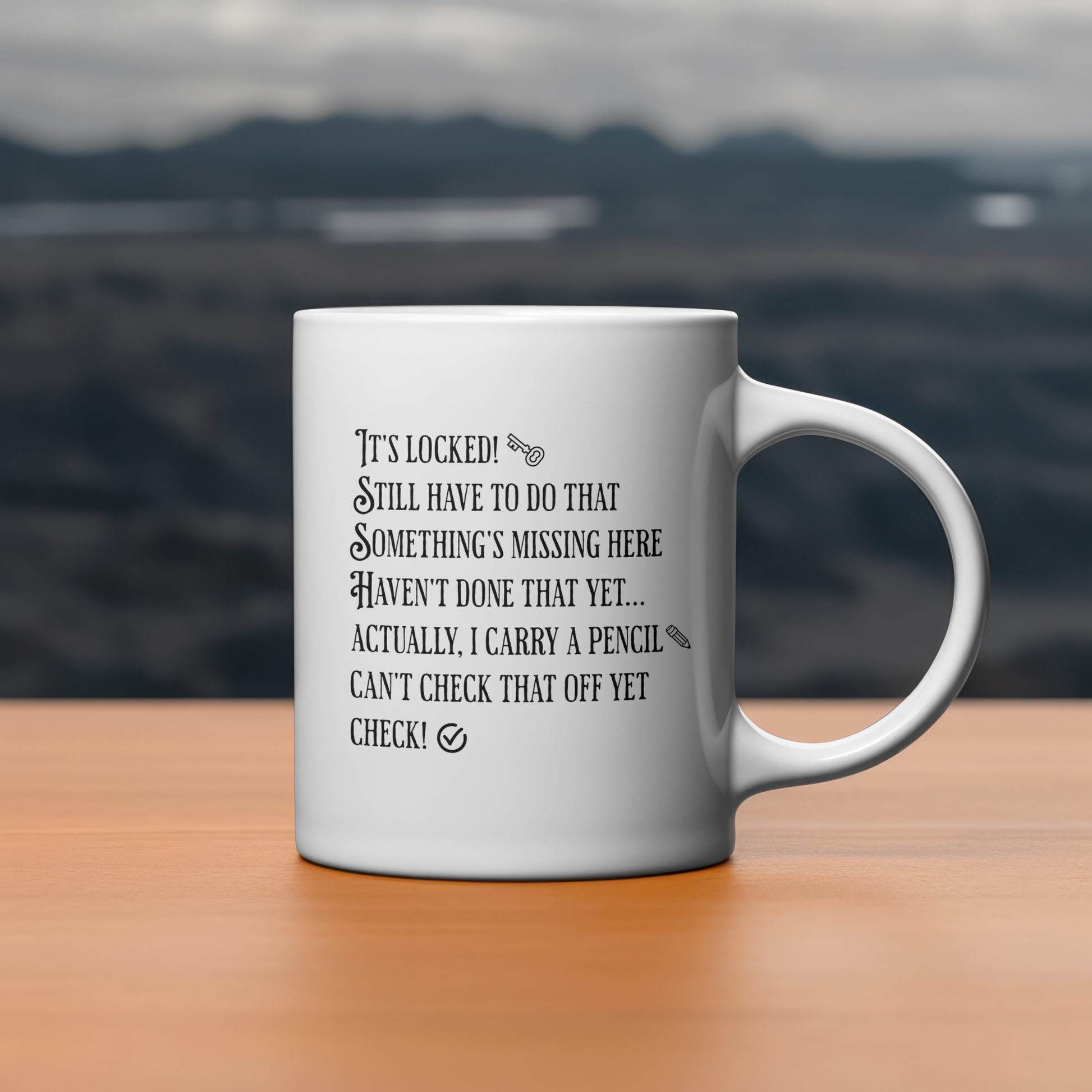 White mug with text from the Nancy Drew video game on a wooden surface with a blurred mountain background
