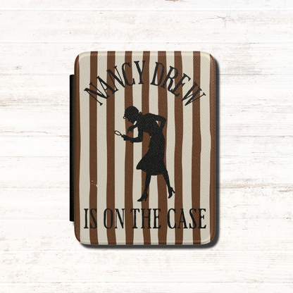 A Nancy Drew Kindle Case that features brown stripes, with a black silhouette of Nancy Drew with a magnifying glass and the text 'NANCY DREW IS ON THE CASE'. Designed by Starlit Prose Bookish Merch Australia.