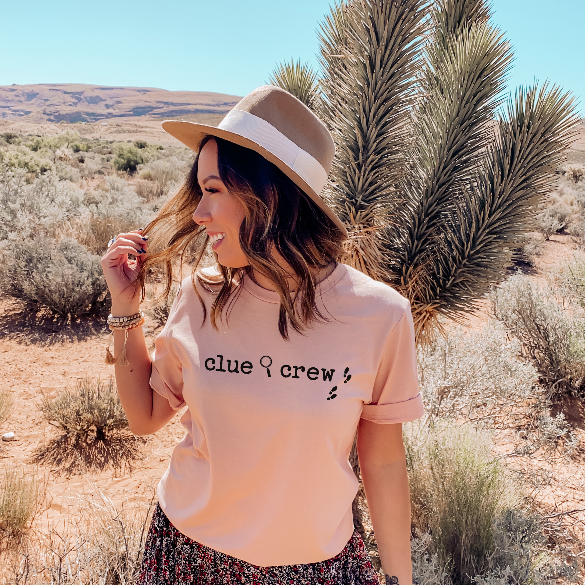 Woman wearing a Heather Peach clue crew' t-shirt in a desert setting