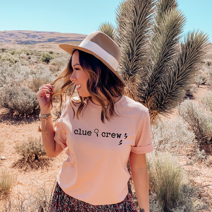 Woman wearing a Heather Peach clue crew' t-shirt in a desert setting