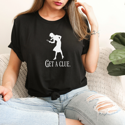 Person wearing a black t-shirt with a graphic and text 'GET A CLUE.'