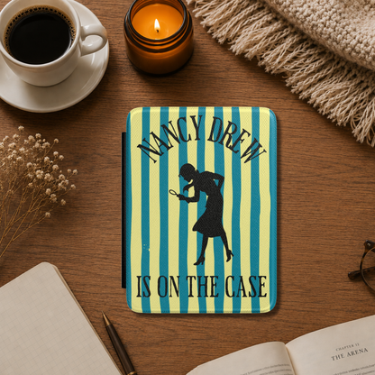 A Nancy Drew Kindle Case that features yellow and blue stripes, with a black silhouette of Nancy Drew with a magnifying glass and the text 'NANCY DREW IS ON THE CASE'. Designed by Starlit Prose Bookish Merch Australia.