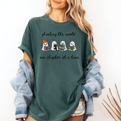 A woman wearing an oversized Seafoam Comfort Colors T-shirt with four cartoon ghosts reading books and the text 'ghosting the world one chapter at a time". Designed by Starlit Prose Bookish Merch Australia