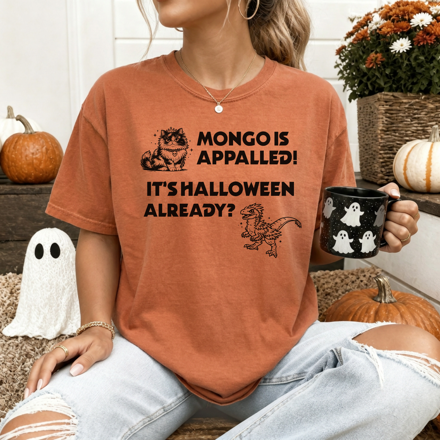 A woman wearing a Yam Comfort Colors t-shirt with a Halloween design that reads 'MONGO IS APPALLED! IT'S HALLOWEEN ALREADY?' with illustrations of Princess Donut and Mongo. Designed by Starlit Prose Bookish Merch Australia