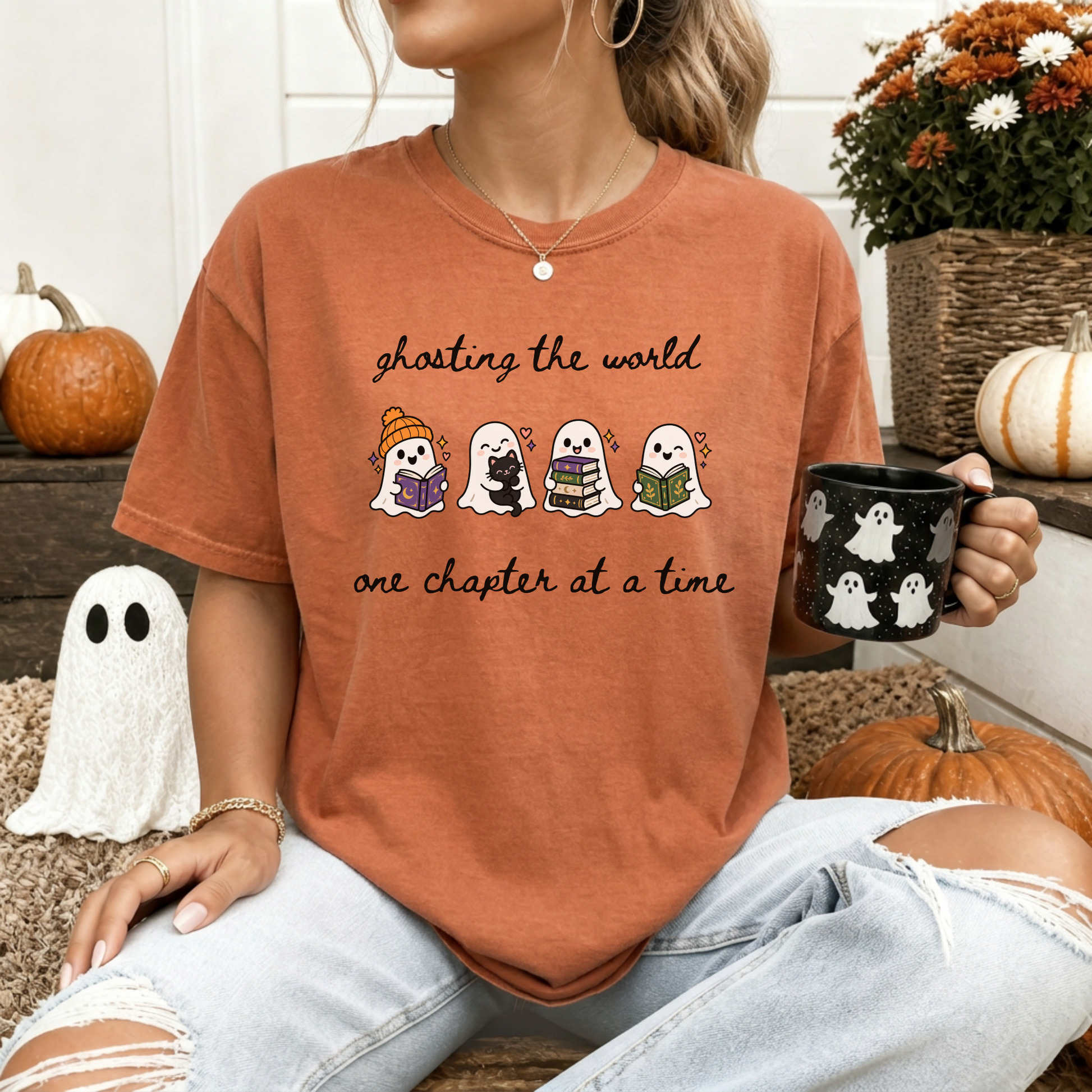 A woman wearing an oversized Yam Comfort Colors T-shirt with four cartoon ghosts reading books and the text 'ghosting the world one chapter at a time". Designed by Starlit Prose Bookish Merch Australia