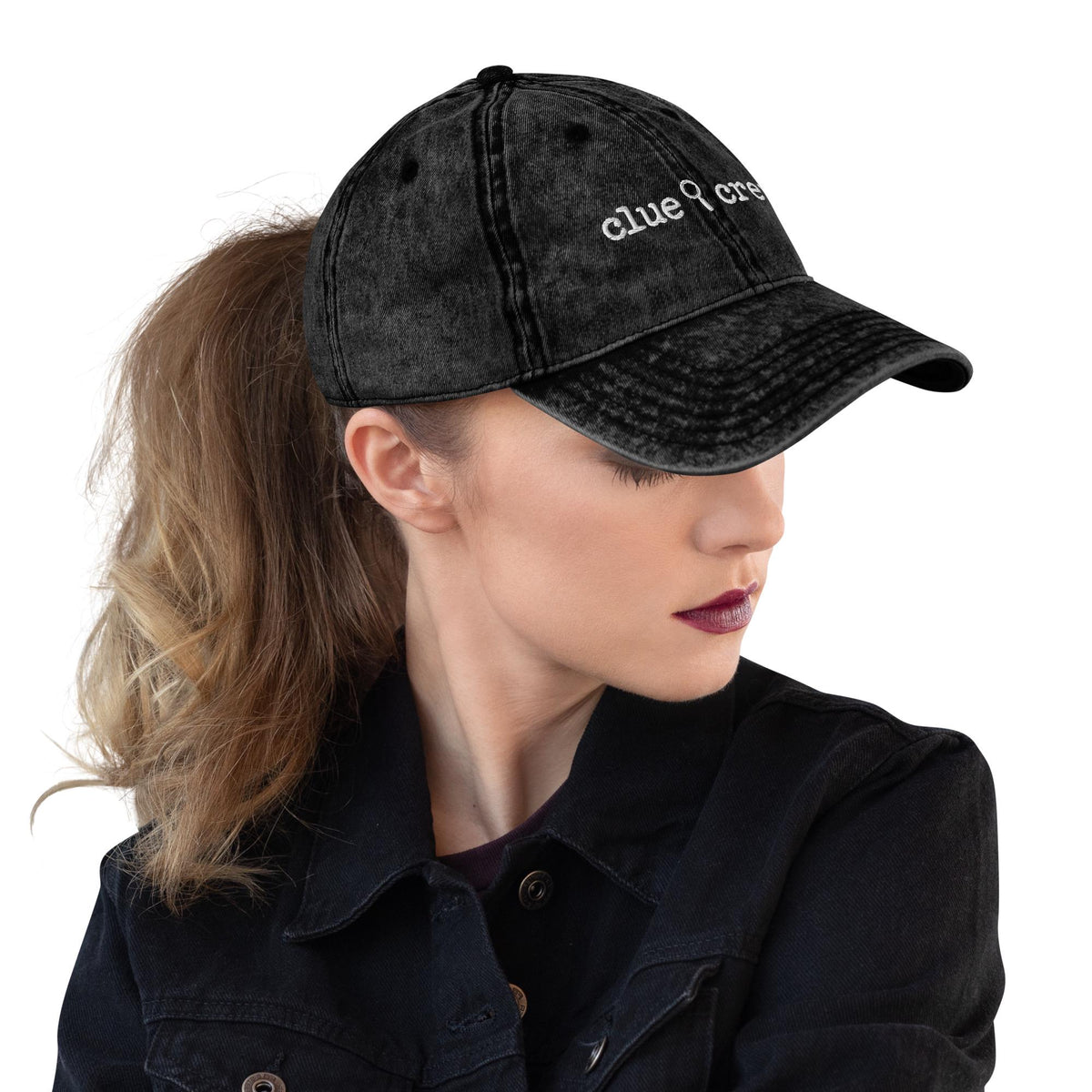 A Nancy Drew vintage distressed style embroidered Dad hat features “Clue Crew” alongside a magnifying glass and tiny footsteps. Designed by Starlit Prose Bookish Merch Australia.