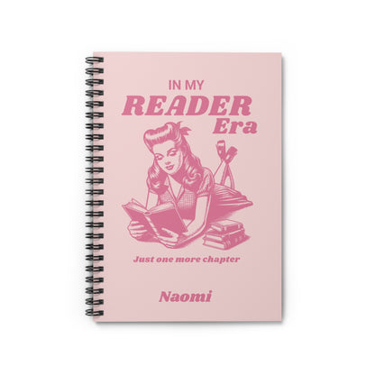 This cute bookish personalised spiral notebook features a soft light pink background, a vintage-inspired pin-up girl reading a book and the phrases "In My Reader Era" and "Just One More Chapter." A personalised section allows you to add the recipient's name, turning an already bookish design into a thoughtful gift made especially for them. Designed by Starlit Prose Bookish Merch Australia.
