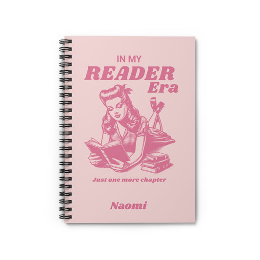 This cute bookish personalised spiral notebook features a soft light pink background, a vintage-inspired pin-up girl reading a book and the phrases "In My Reader Era" and "Just One More Chapter." A personalised section allows you to add the recipient's name, turning an already bookish design into a thoughtful gift made especially for them. Designed by Starlit Prose Bookish Merch Australia.