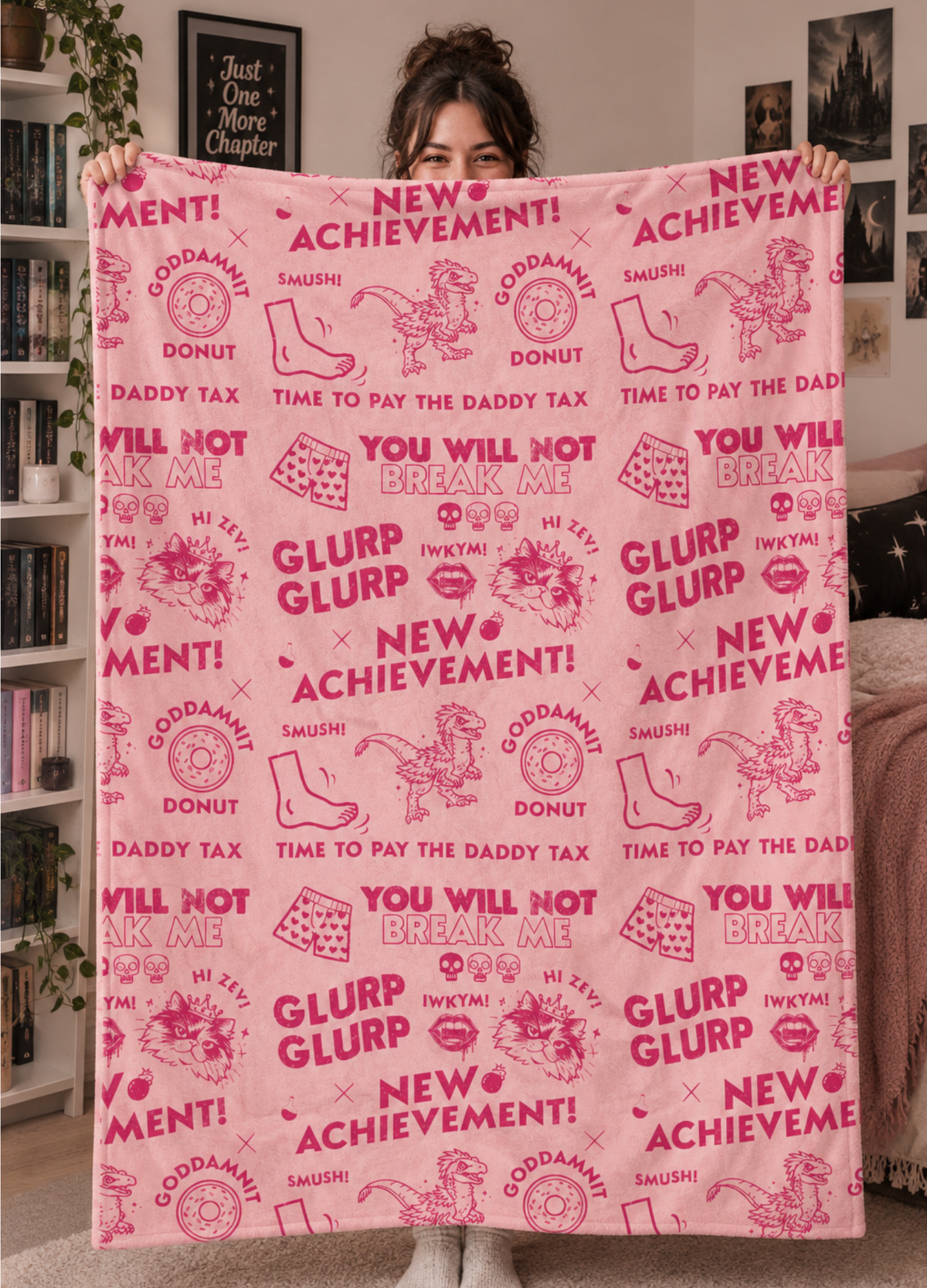 A person holds up a large pink blanket or throw in a bedroom setting. The blanket features a Dungeon Crawler Carl repeating dark pink collage design, with the words 'NEW ACHIEVEMENT!', 'GLURP GLURP', 'DADDY TAX', and various DCC designs included in a distressed design style. Designed by Starlit Prose Bookish Merch Australia