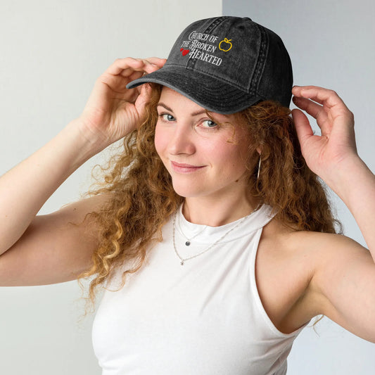 Once Upon a Broken Heart embroidered hat , distressed Vintage style hat features text that says “Church of the Broken Hearted”, with a delicate gold apple outline, and tiny red hearts. Designed by Starlit Prose Bookish Merch Australia.