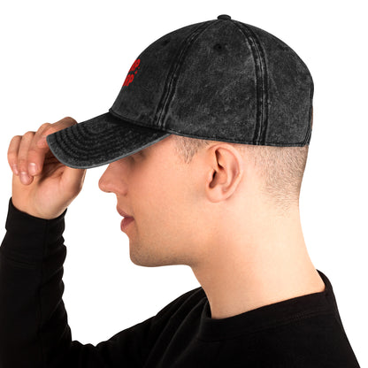 Side view of a Man wearing A black acid-wash baseball cap with 'GLURP GLURP' embroidered in red on the front, a quote from Dungeon Crawler Carl book series, shown against a plain white background. Designed by Starlit Prose Bookish Merch Australia