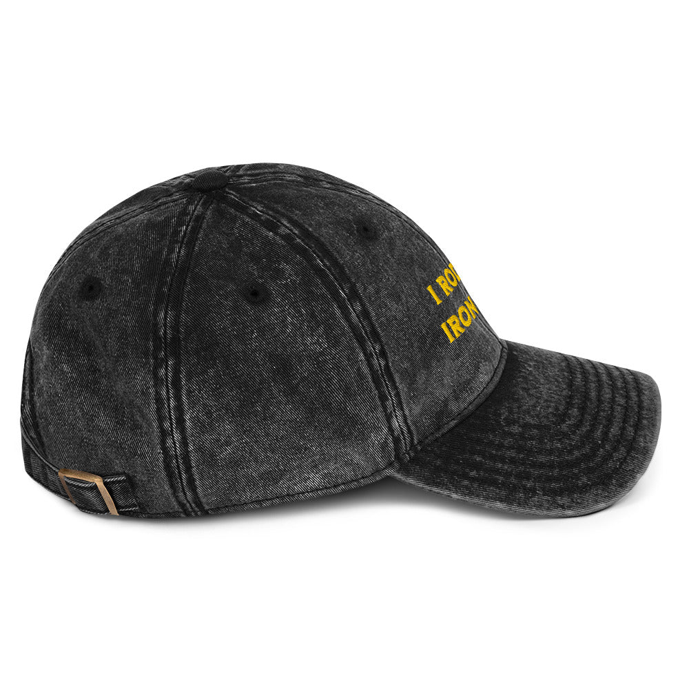 Side view of A black acid-wash baseball cap with yellow embroidered text reading 'I RODE THE IRON TANGLE' on the front, inspired by Dungeon Crawler Carl, shown against a plain white background. Starlit Prose Bookish Merch Australia