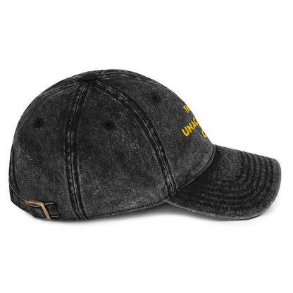 Side view of A washed black denim baseball cap that says "This is unacceptable Carl" in yellow embroidered text. Quote from Princess Donut of Dungeon Crawler Carl book series. Designed by Starlit Prose Bookish Merch Australia