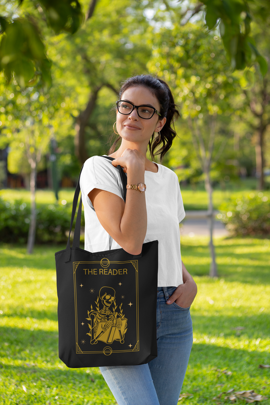 Woman in park holding The Reader Tarot Card Bookish Tote Bag